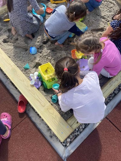 Kinder spielen in der fertigen Sandkiste 